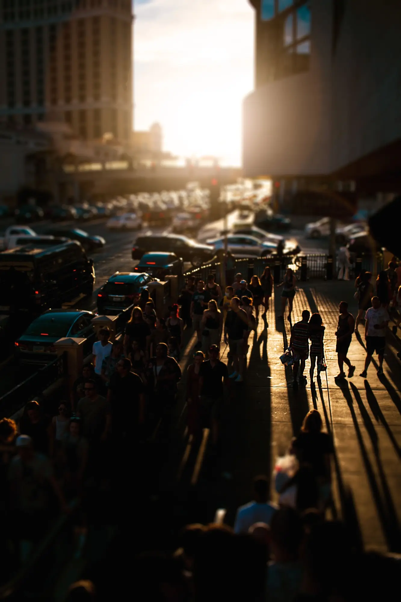 Visitors walking along a busy Las Vegas sidewalk at sunset